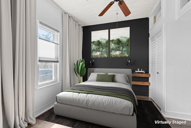 bedroom with baseboards, a ceiling fan, and wood finished floors