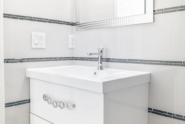 bathroom featuring vanity and tile walls