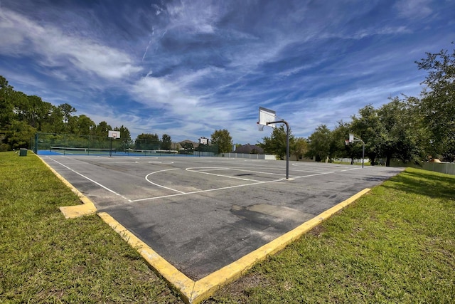 view of sport court featuring a lawn and tennis court