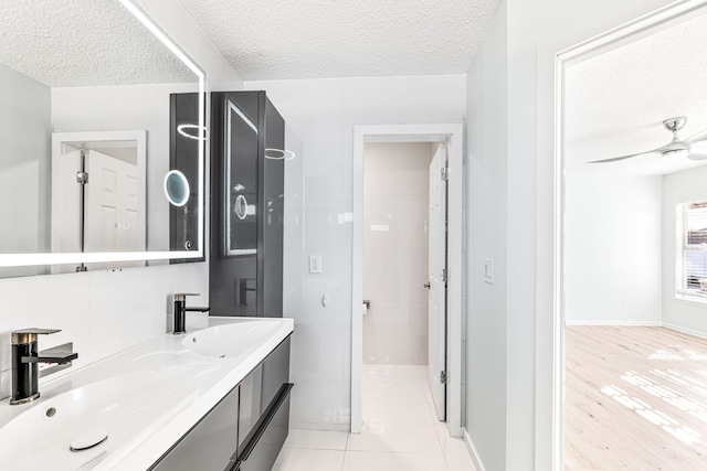 bathroom with vanity, wood-type flooring, a textured ceiling, and ceiling fan