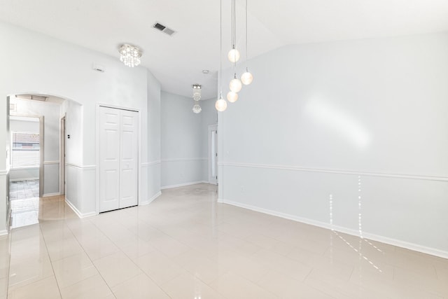 tiled empty room with lofted ceiling