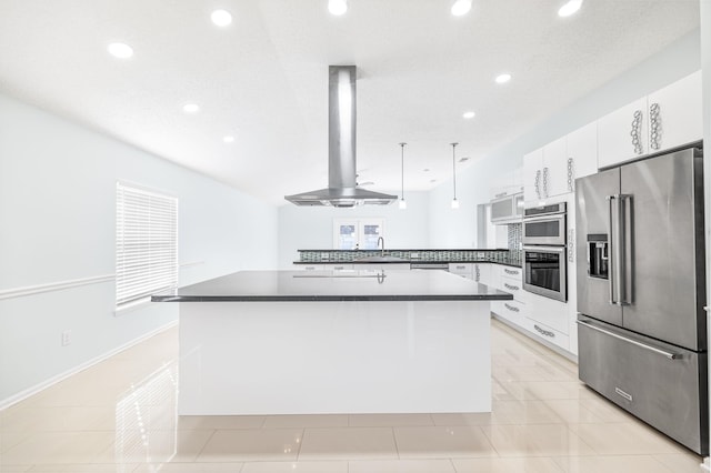 kitchen featuring white cabinets, decorative light fixtures, kitchen peninsula, island exhaust hood, and stainless steel appliances