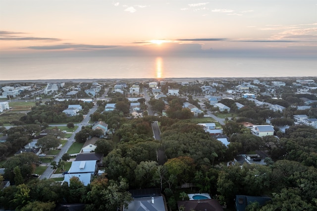 aerial view at dusk featuring a water view