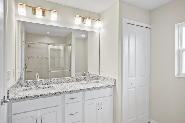 bathroom with an enclosed shower, vanity, and toilet