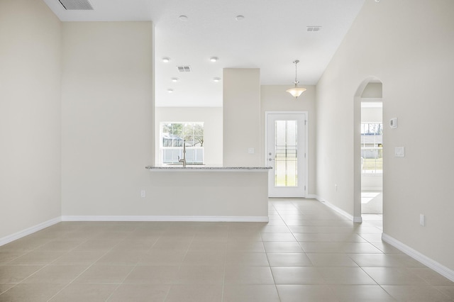 spare room with a wealth of natural light and light tile patterned floors