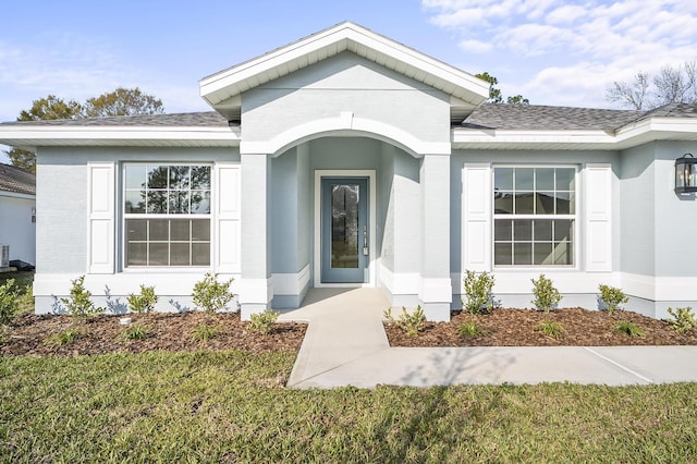 entrance to property with a lawn