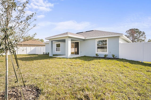 rear view of property featuring a lawn and a patio area