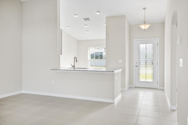 kitchen featuring sink, hanging light fixtures, light stone countertops, white cabinets, and kitchen peninsula