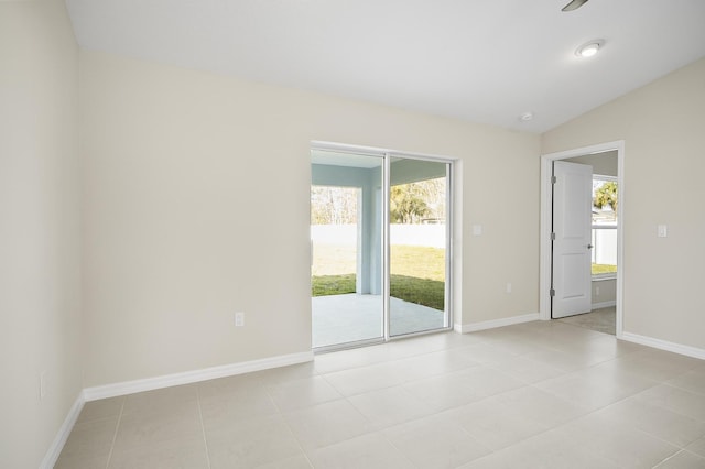 empty room featuring light tile patterned flooring and lofted ceiling