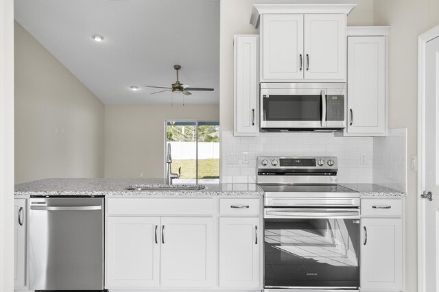 kitchen with stainless steel appliances, white cabinetry, sink, and decorative backsplash