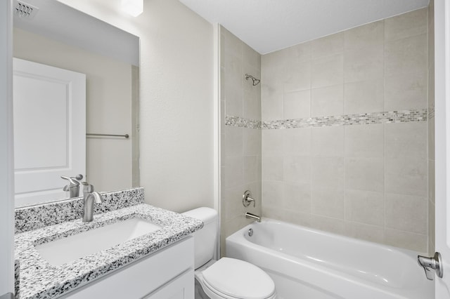 full bathroom with tiled shower / bath combo, vanity, and toilet