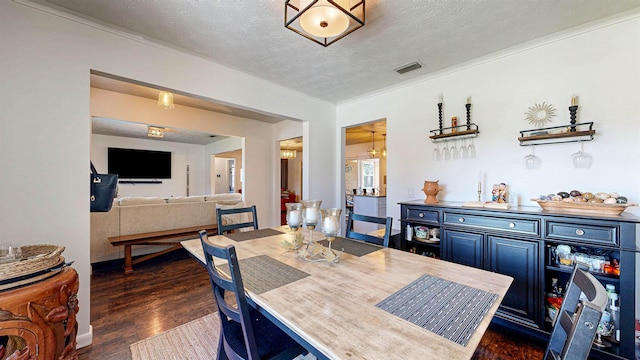 dining space featuring a textured ceiling, dark wood-type flooring, and visible vents