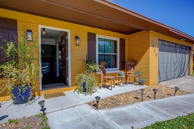 property entrance featuring brick siding and an attached garage