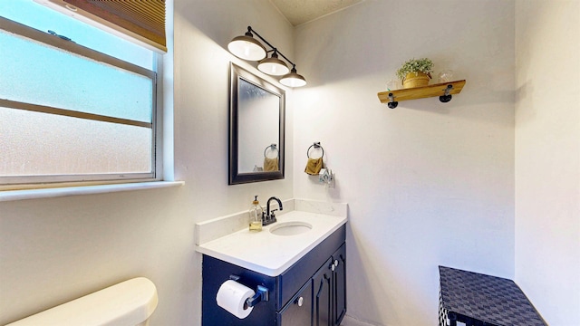 bathroom featuring toilet, plenty of natural light, and vanity