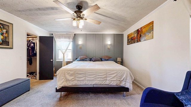 bedroom with a textured ceiling, carpet floors, and crown molding