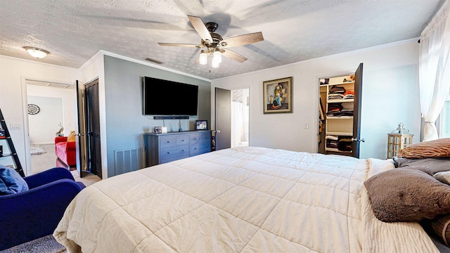 bedroom featuring a textured ceiling, ornamental molding, a closet, and visible vents