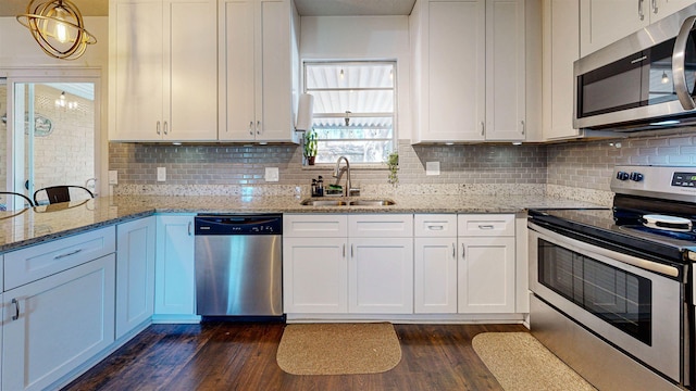 kitchen with dark wood-style floors, white cabinetry, stainless steel appliances, and a sink