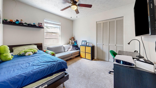 bedroom featuring a textured ceiling, ceiling fan, a closet, and carpet flooring