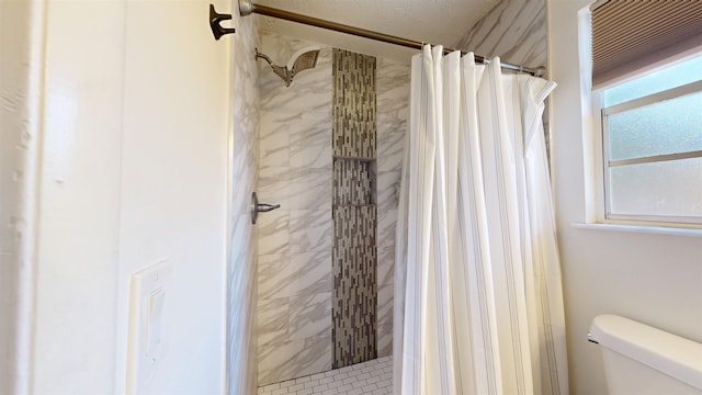 bathroom with a shower stall and toilet