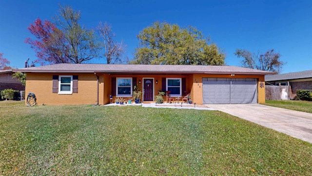 ranch-style home featuring driveway, a front lawn, an attached garage, and brick siding