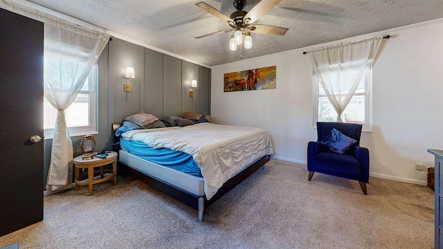 carpeted bedroom with ornamental molding, ceiling fan, a textured ceiling, and baseboards