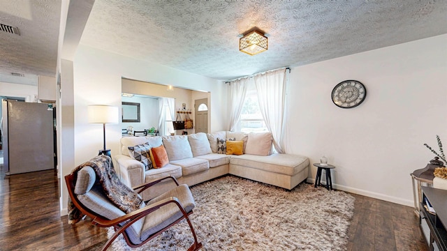 living room with a textured ceiling, baseboards, and hardwood / wood-style floors