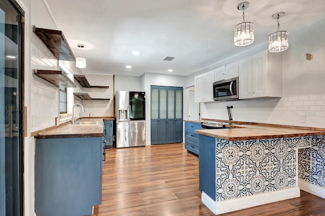 132 Southwind Cir, Saint Augustine, FL 32080 - kitchen featuring stainless steel appliances, open shelves, butcher block counters, wood finished floors, and tasteful backsplash
