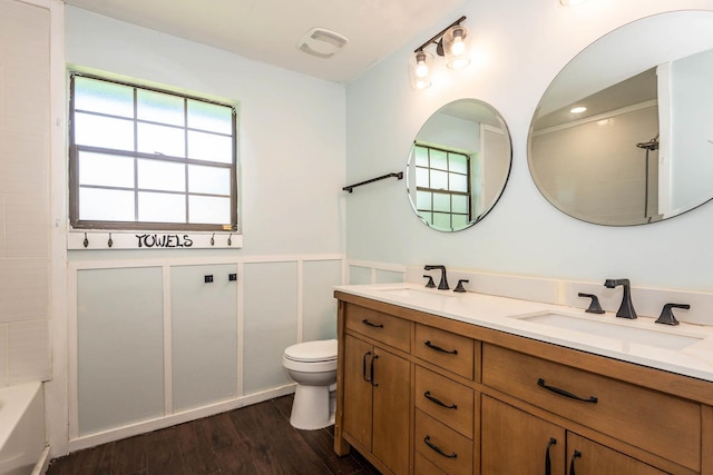132 Southwind Cir, Saint Augustine, FL 32080 - full bathroom with double vanity, wood finished floors, wainscoting, and shower / bathtub combination