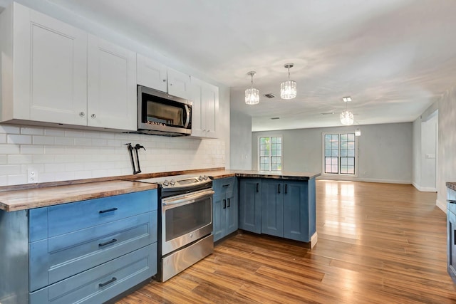 132 Southwind Cir, Saint Augustine, FL 32080 - kitchen featuring appliances with stainless steel finishes, a peninsula, open floor plan, tasteful backsplash, and wood finished floors