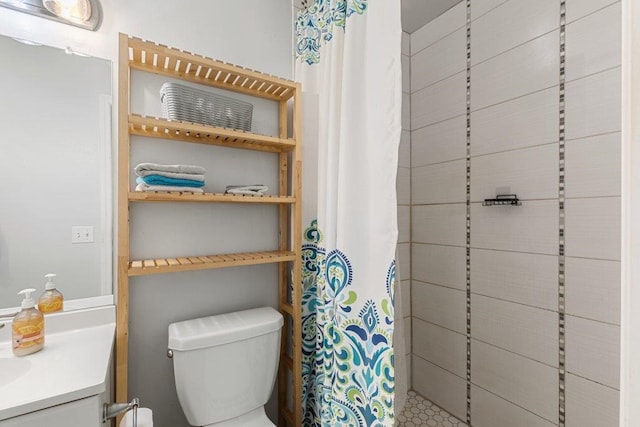 full bathroom with a tile shower, toilet, and vanity