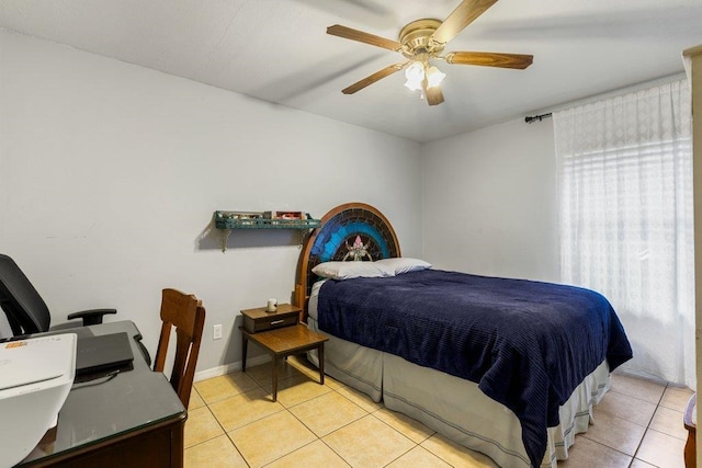 bedroom featuring light tile patterned flooring, an office area, a ceiling fan, and baseboards
