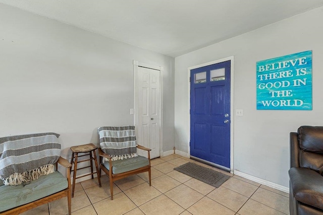 foyer featuring baseboards and light tile patterned flooring