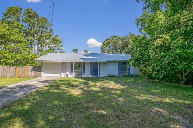 ranch-style home featuring concrete driveway, a garage, and metal roof