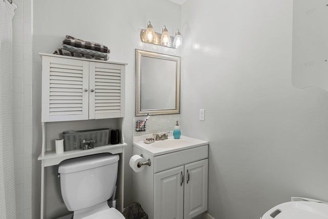 bathroom with toilet, vanity, and a shower with shower curtain