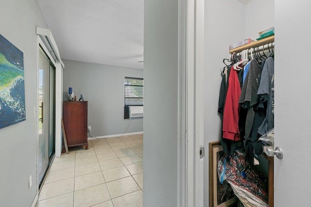 corridor featuring tile patterned flooring, baseboards, and cooling unit