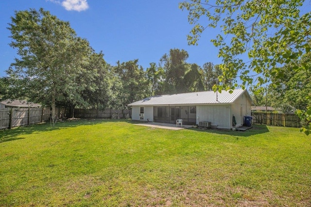 back of property with metal roof and a patio