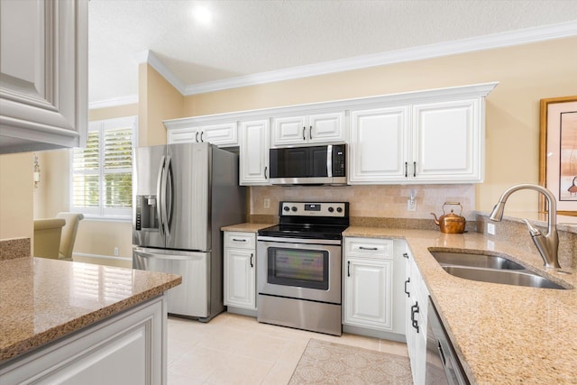 501 Olympic Cir, Saint Augustine, FL 32092 - kitchen with appliances with stainless steel finishes, ornamental molding, white cabinetry, light stone counters, and decorative backsplash