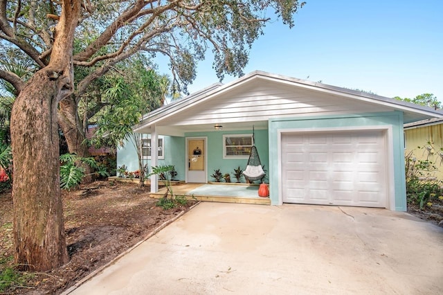 ranch-style home featuring covered porch and a garage