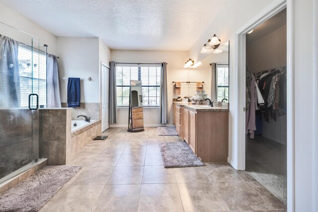 bathroom with vanity, tile patterned flooring, independent shower and bath, and a textured ceiling