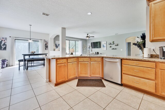 kitchen with decorative light fixtures, light tile patterned floors, stainless steel dishwasher, kitchen peninsula, and a textured ceiling