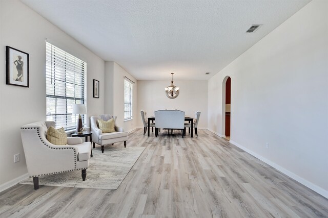 interior space featuring a notable chandelier, a textured ceiling, and light hardwood / wood-style floors