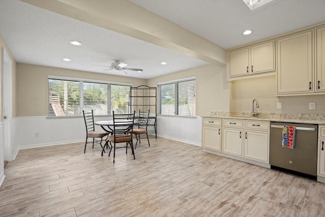 kitchen featuring cream cabinets, sink, stainless steel dishwasher, ceiling fan, and light hardwood / wood-style floors