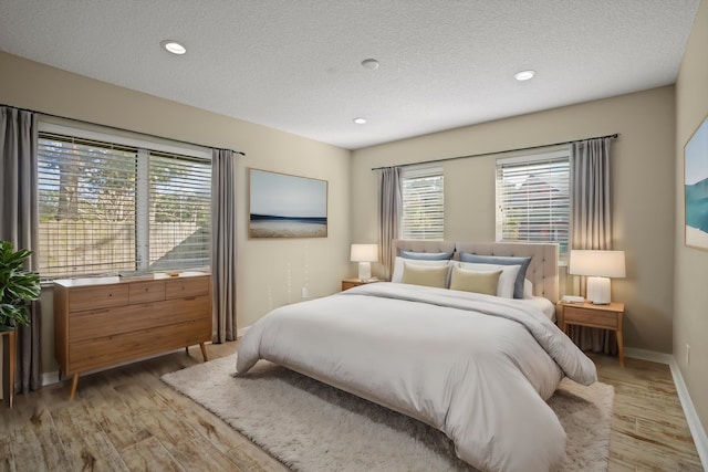 bedroom featuring light wood-type flooring and a textured ceiling