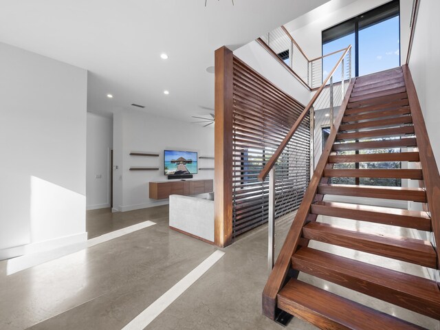 stairs with concrete floors and a wealth of natural light