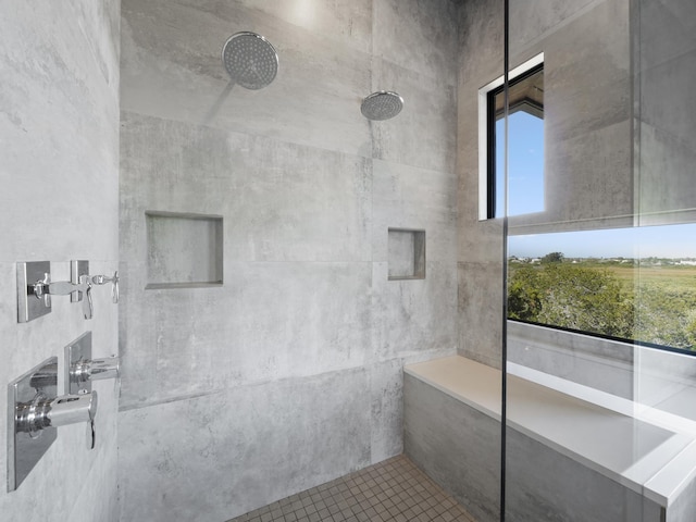 bathroom with tiled shower and plenty of natural light