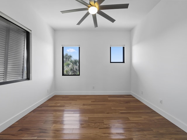 unfurnished room with dark wood-type flooring, ceiling fan, and a healthy amount of sunlight