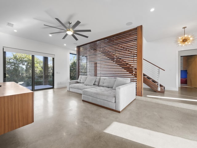 unfurnished living room with concrete flooring and ceiling fan with notable chandelier