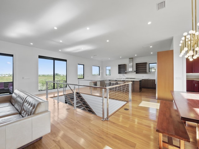 living room featuring light hardwood / wood-style flooring, a notable chandelier, and sink