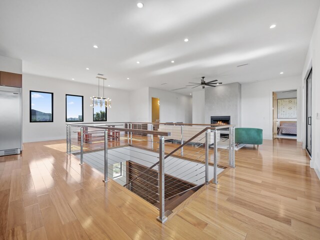 corridor with a chandelier and light hardwood / wood-style flooring