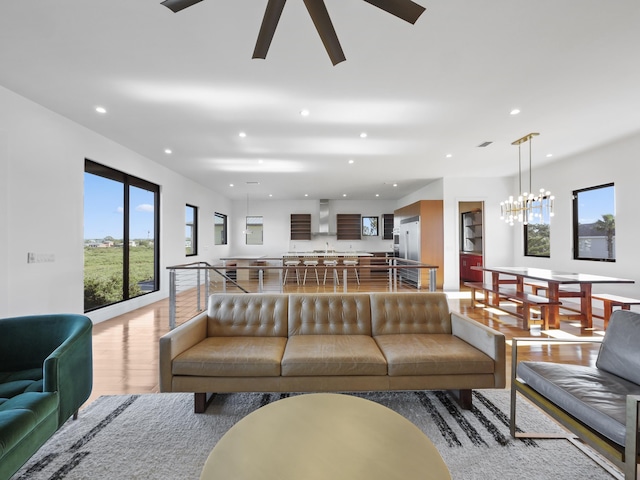 living room featuring hardwood / wood-style floors and ceiling fan with notable chandelier